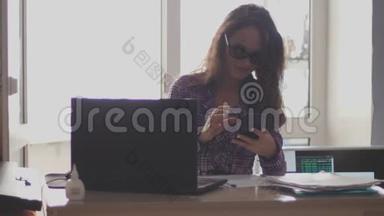女商人戴着眼镜，在笔记本电脑和电话上工作。 慢动作。 3840x2160
